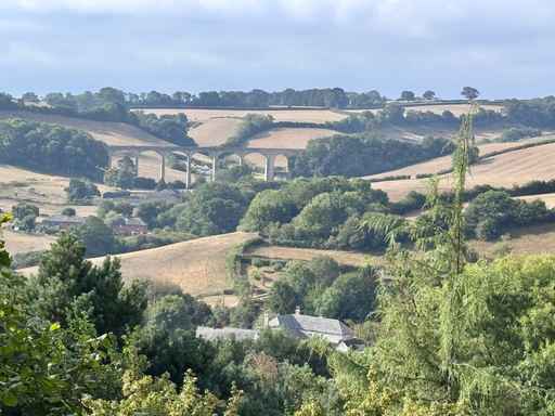 Rolling countryside landscape featuring a distant stone viaduct.