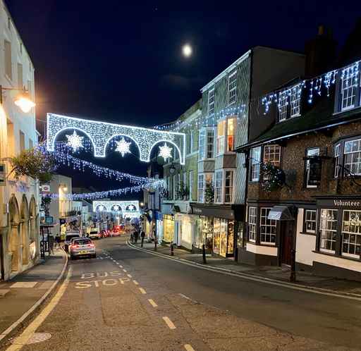 Charming town street illuminated with festive Christmas lights at night.