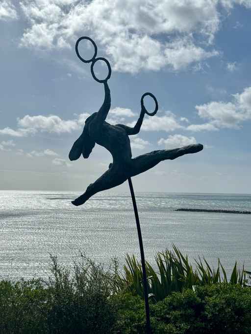 Sculpture silhouetted against the sea and sky.